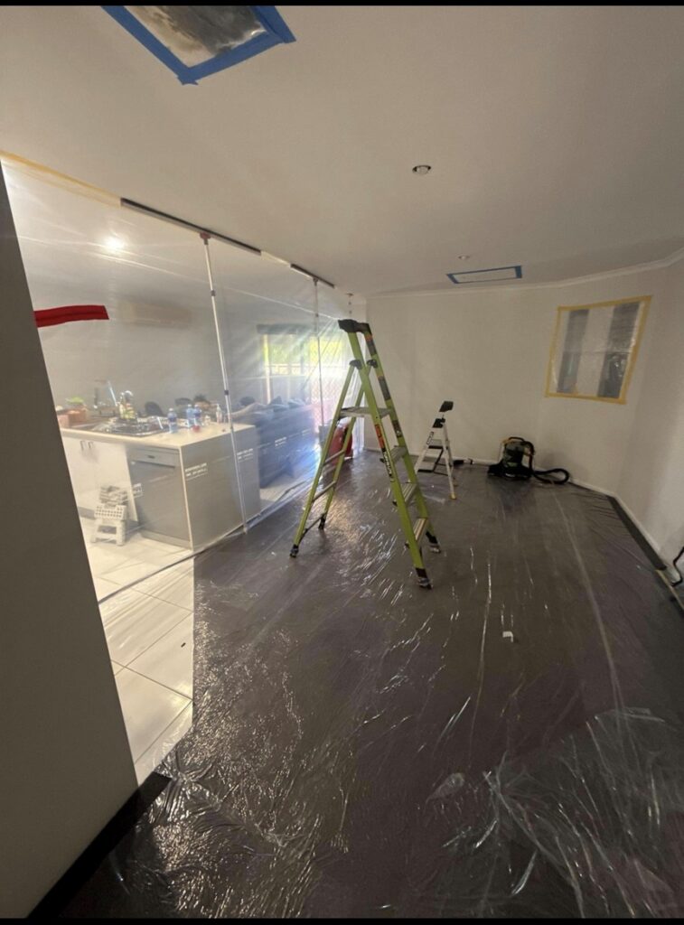 Mould remediation work zone with floor protection and masked vents inside containment