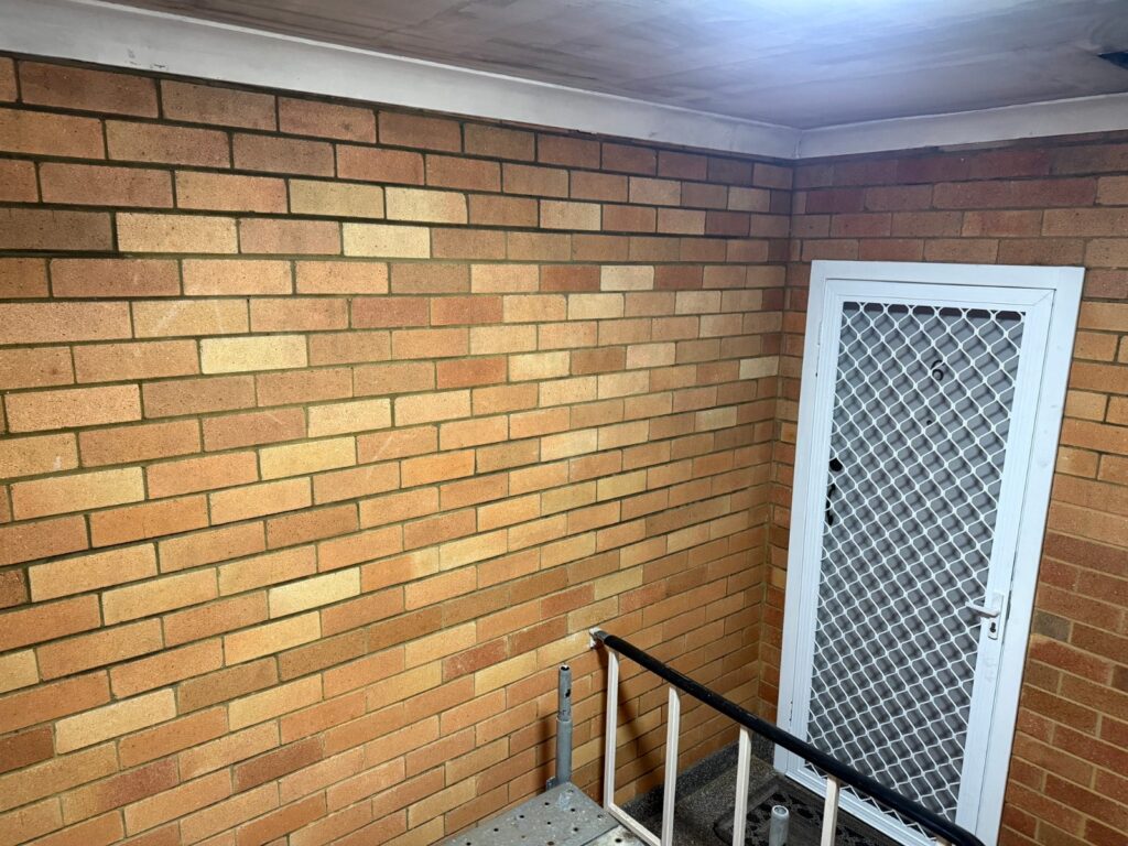 Clean face brick walls and entry in an Adamstown apartment common area after dry ice blasting